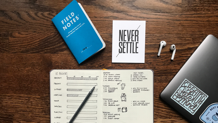 books on a table. "NEVER SETTLE"