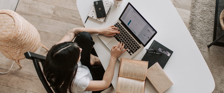 Woman sitting in office typing on laptop